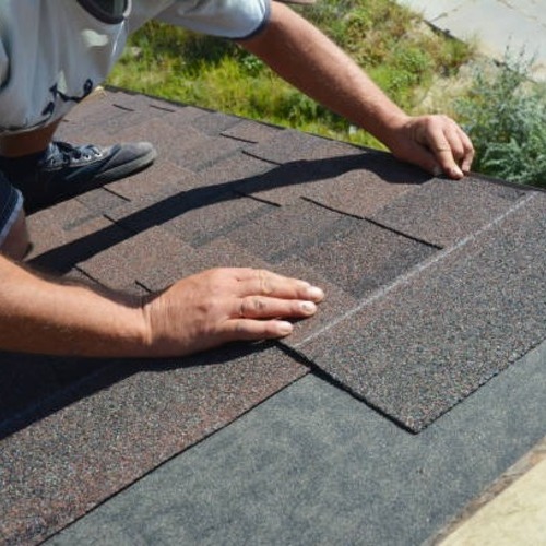roofer repairing damaged shingles